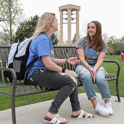 两个学生在公园的长椅上聊天